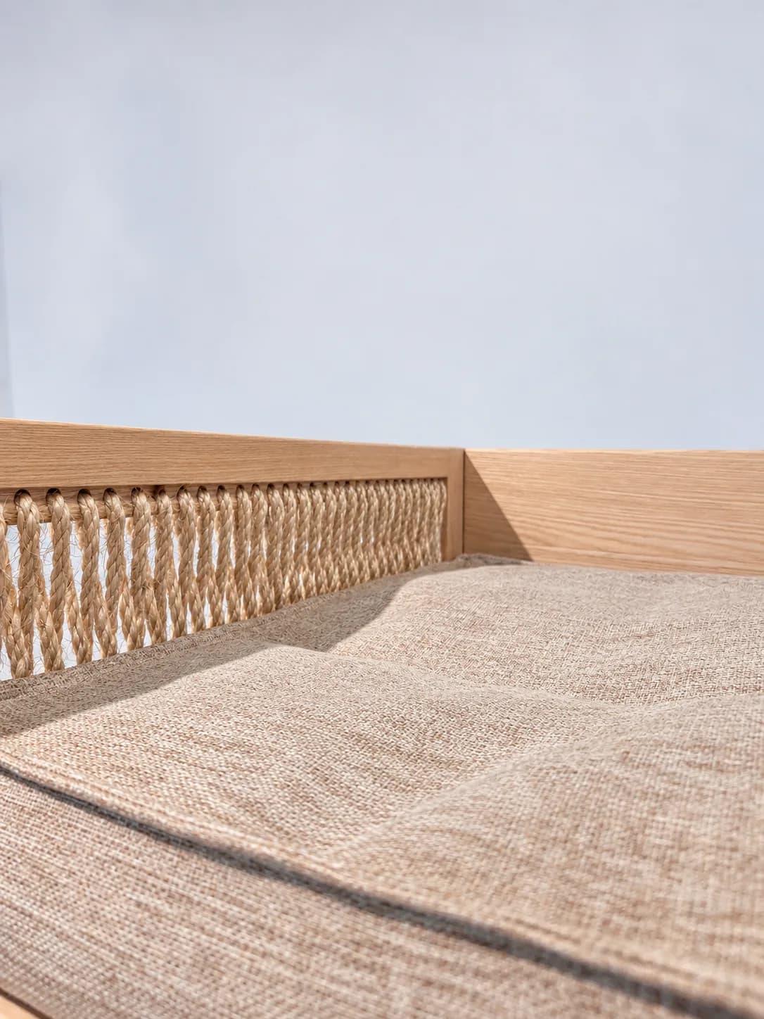 Detail of the side panel with hand-woven rope and of the mattress